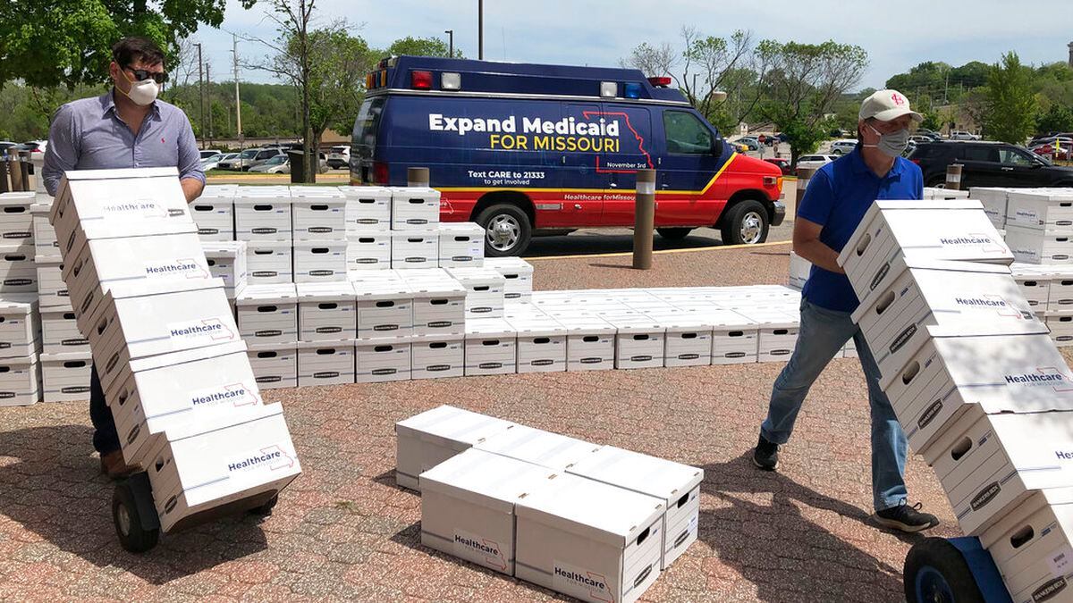 FILE - In this May 1, 2020, file photo, campaign workers David Woodruff, left, and Jason White, right, deliver boxes of initiative petitions signatures to the Missouri secretary of state's office in Jefferson City, Mo. President Donald Trump is still trying to overturn “Obamacare,” but his predecessor’s health care law keeps gaining ground in places where it was once unwelcome. Missouri voters this week approved Medicaid expansion by a 53% to 47% margin, making the conservative state the seventh to do so under Trump.