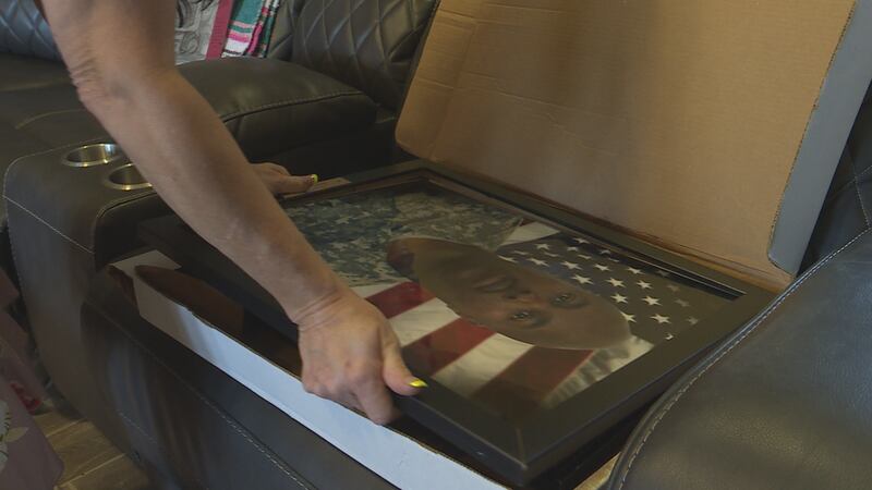 Kaycee Lee puts a portrait of her husband Sgt. Dennis Lee in safe keeping, hoping to give it to...