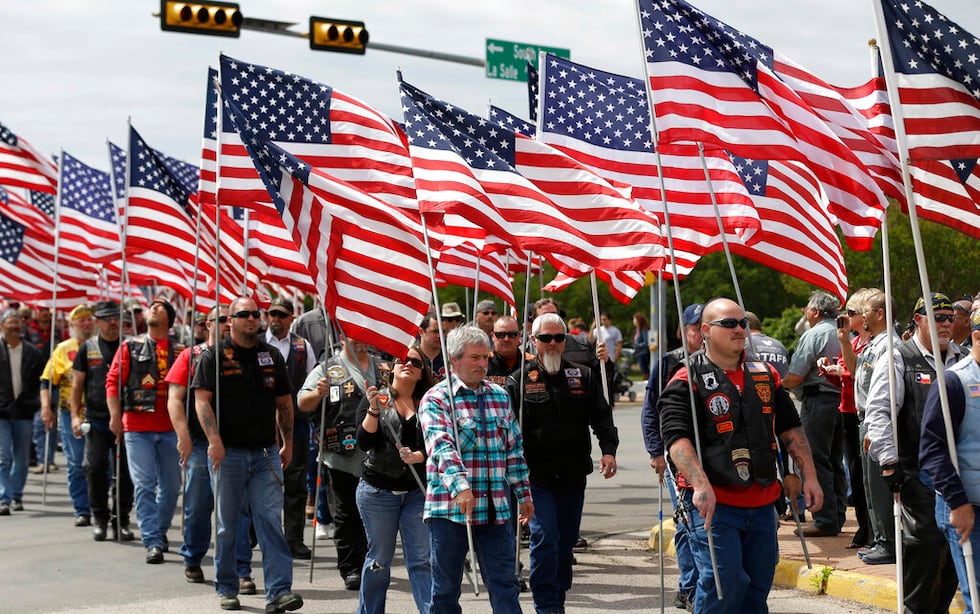 Members of the Patriot Guard line the road for a procession prior to a memorial service for...