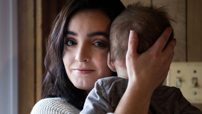 Sydney Sigler, 26, holds her daughter in her home this week in Robinson. Sigler says she's...