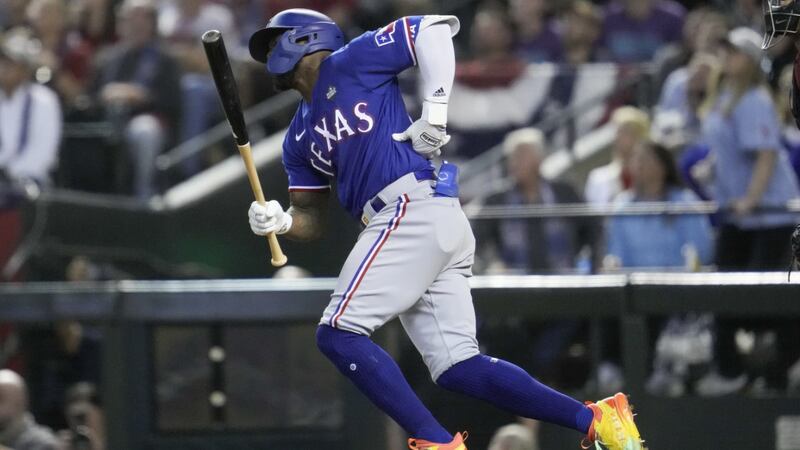 Texas Rangers' Adolis Garcia grabs his left side after his swing during the eighth inning in...
