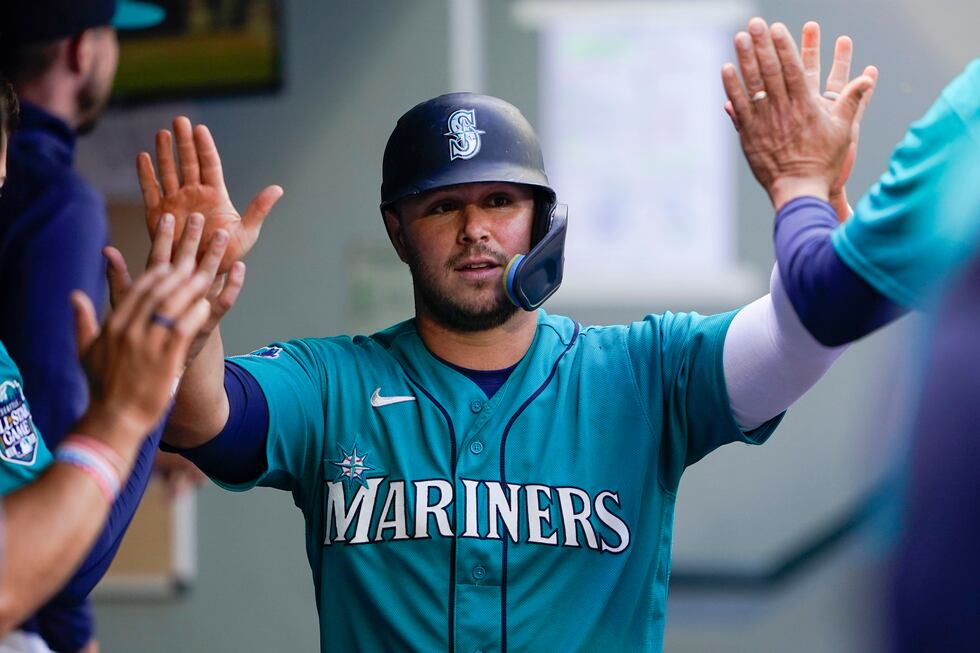 FILE - Seattle Mariners' Ty France is greeted in the dugout after scoring against the Los...