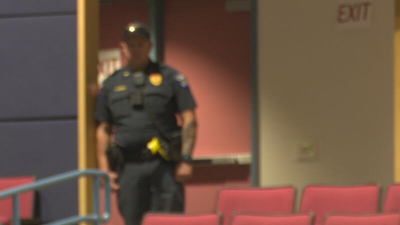 A police officer stands guard as residents gather on a Killeen ISD campus to discuss safety...