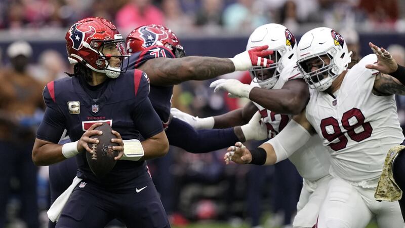 Houston Texans quarterback C.J. Stroud, left, prepares to throw a pass under pressure from...