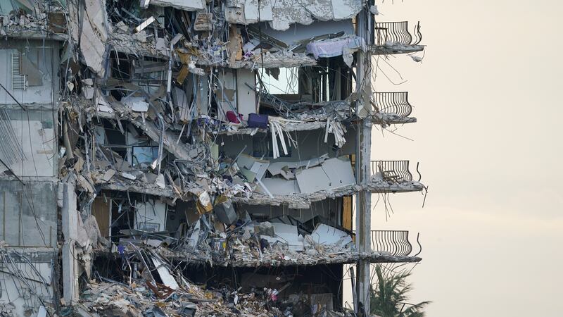 FILE - A giant tarp, bottom, covers a section of rubble where search and rescue personnel...