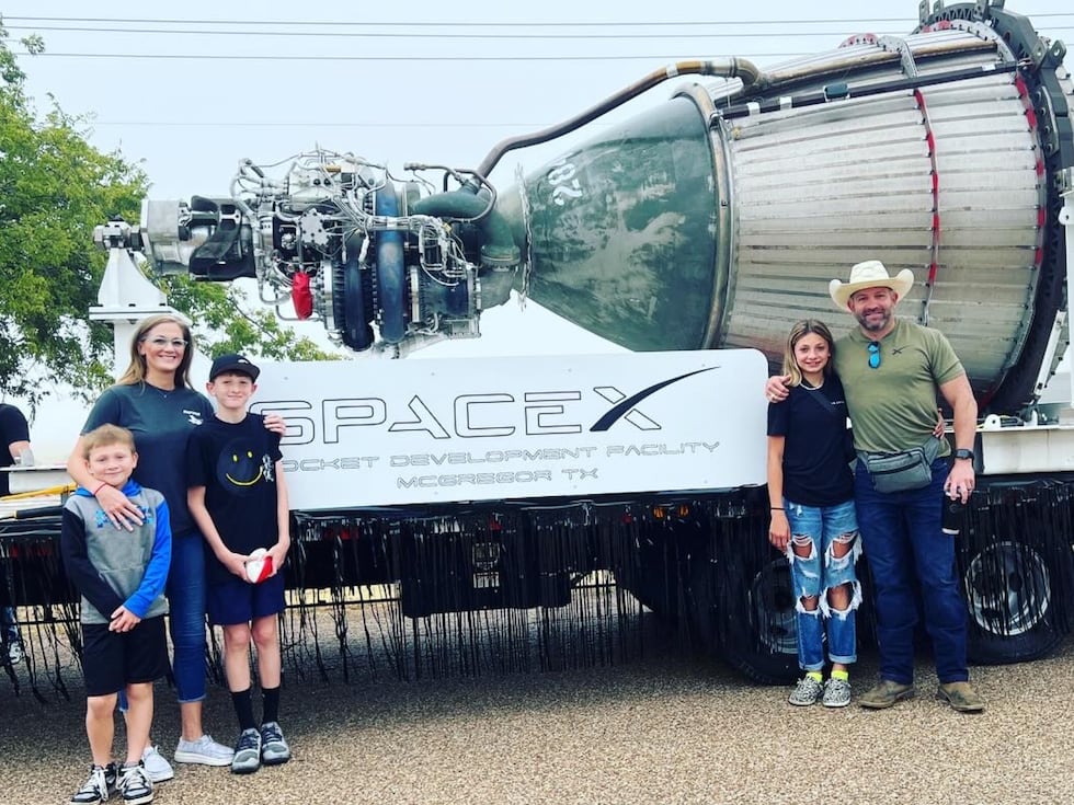 A McGregor family poses next to SpaceX engine