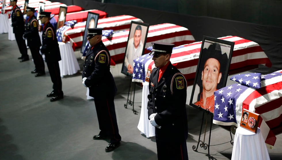 FILE - In this April 25, 2013 file photo, an honor guard stands in front of caskets prior to a...